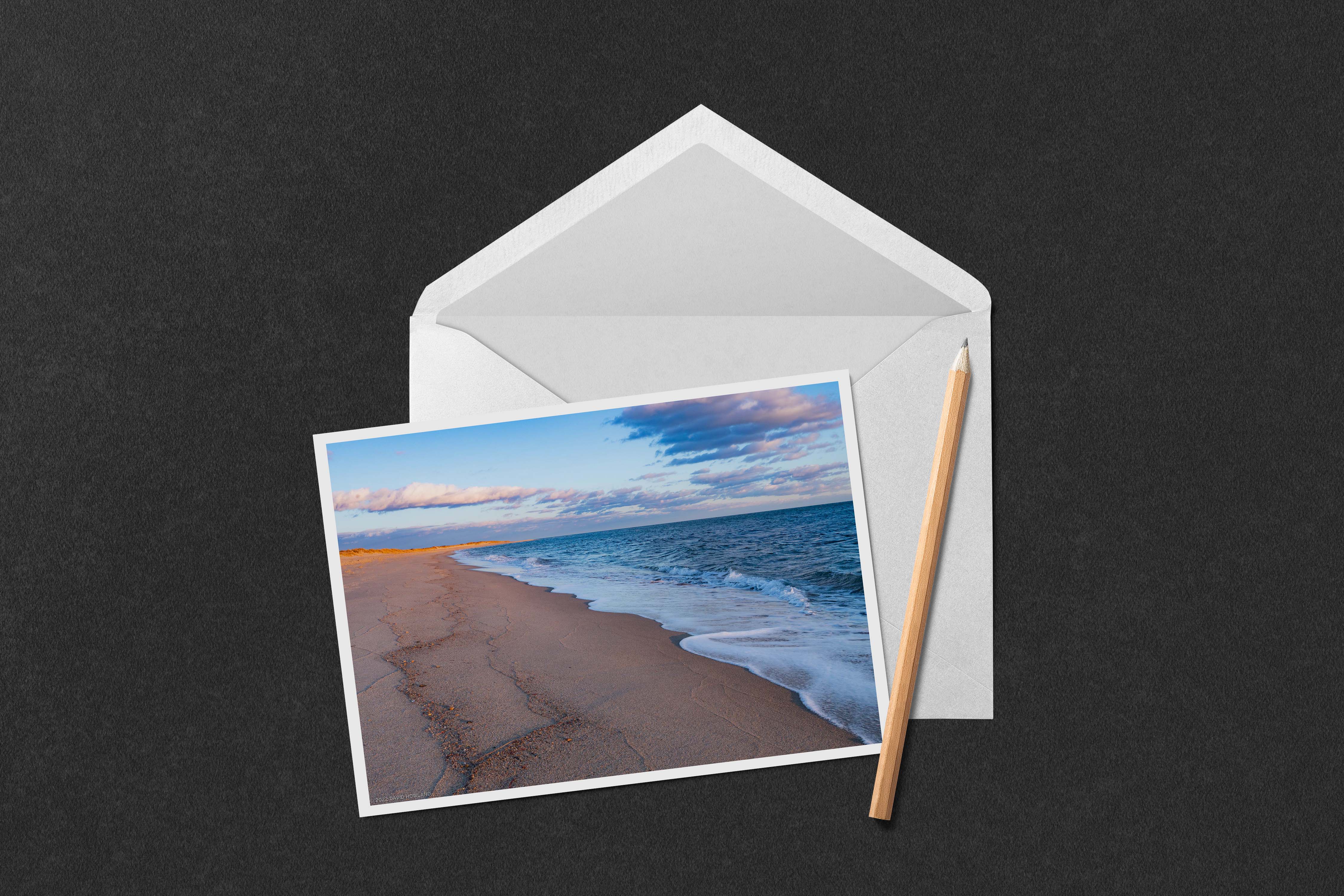A photo of waves rolling onto a sandy beach at sunset in South Cape Beach State Park on Cape Cod.
